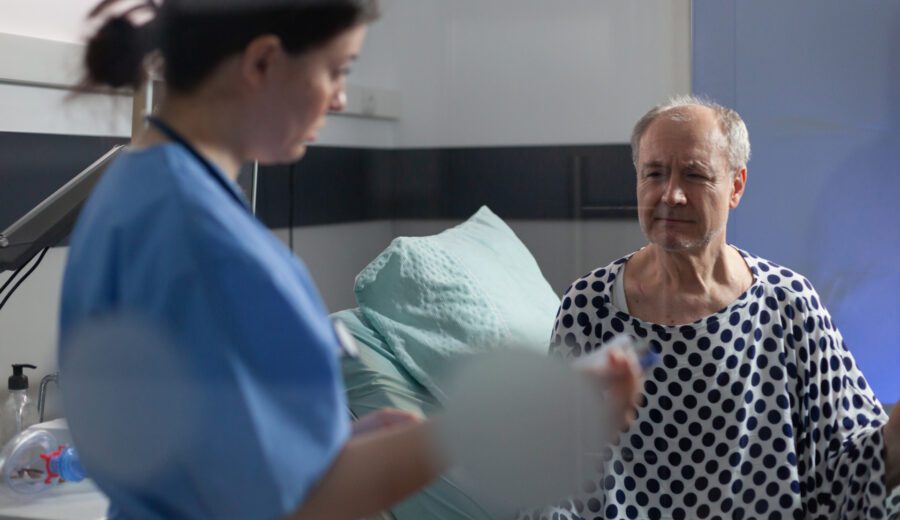 Medical staff with stethoscope questioning sick senior man